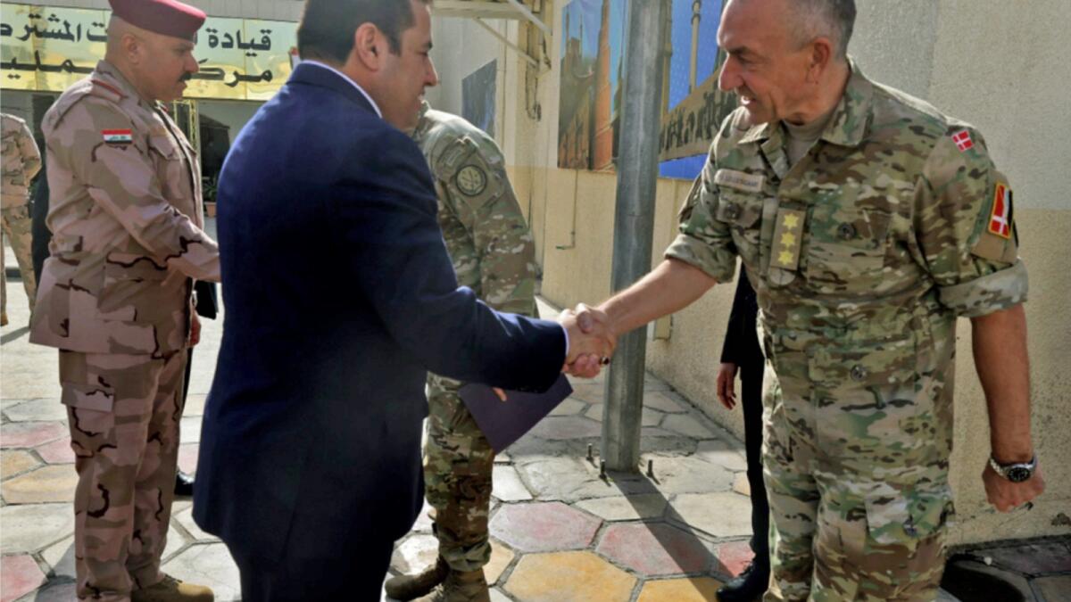 Iraqi National Security Adviser Qassem Al Araji shakes hands with NATO Mission Iraq Commander Lieutenant-General Michael Lollesgaard as they meet at the Joint Operations Centre in the capital Baghdad's 'Green Zone' on Thursday. — AFP