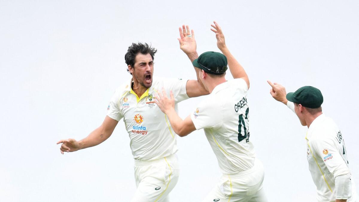 Australian fast bowler Mitchell Starc (left) celebrates after dismissing England opener Rory Burns with the first ball of the match at the Gabba in Brisbane on Wednesday. — AFP