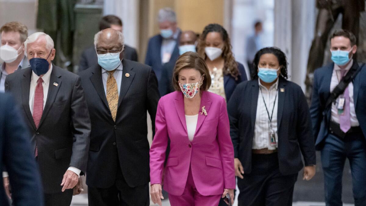 Speaker of the House Nancy Pelosi, joined from left by House Majority Leader Steny Hoyer, and House Majority Whip James Clyburn, walk to update reporters about the infrastructure bill at the Capitol in Washington. – AP