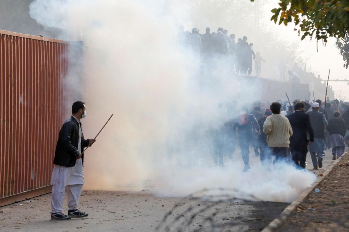 Supporters of former Pakistani Prime Minister Imran Khan walk amid the tear gas during a clash outside Federal Judicial Complex in Islamabad, Pakistan. March 18. Photo: Reuters
