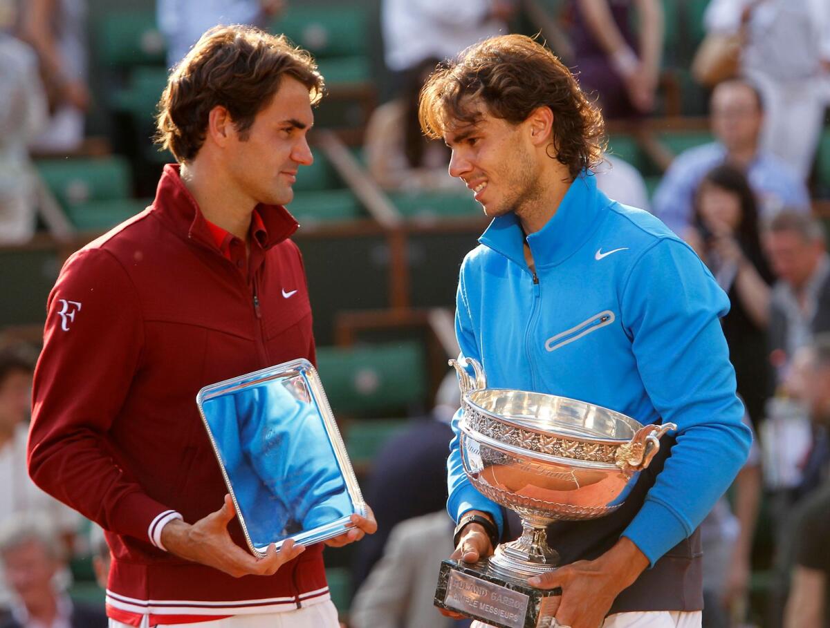 Rafael Nadal (right) and Roger Federer pose with their trophies after the 2011 French Open final. (AP file)