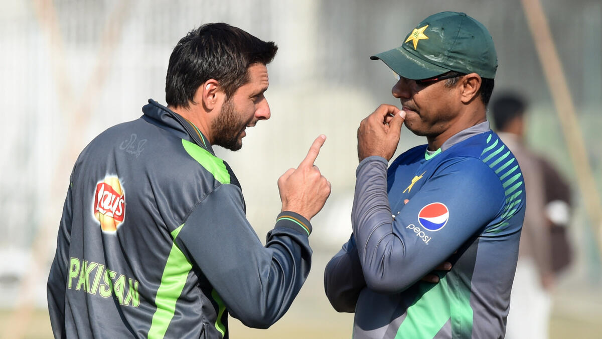Pakistani cricketer Shahid Afridi (L) talks with coach Waqar Younis during a practice session at a camp for the Pakistan Super League (PSL) in Lahore.