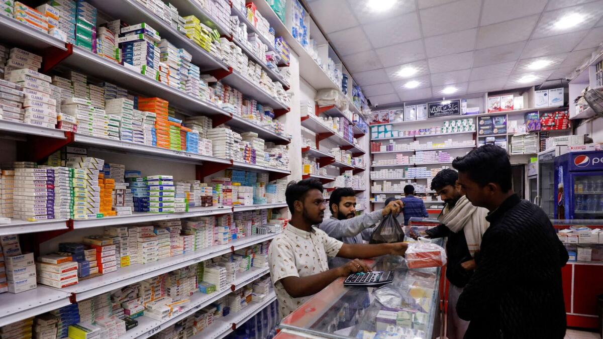 Customers buy medicine from a medical supply store in Karachi, Pakistan. — Reuters file