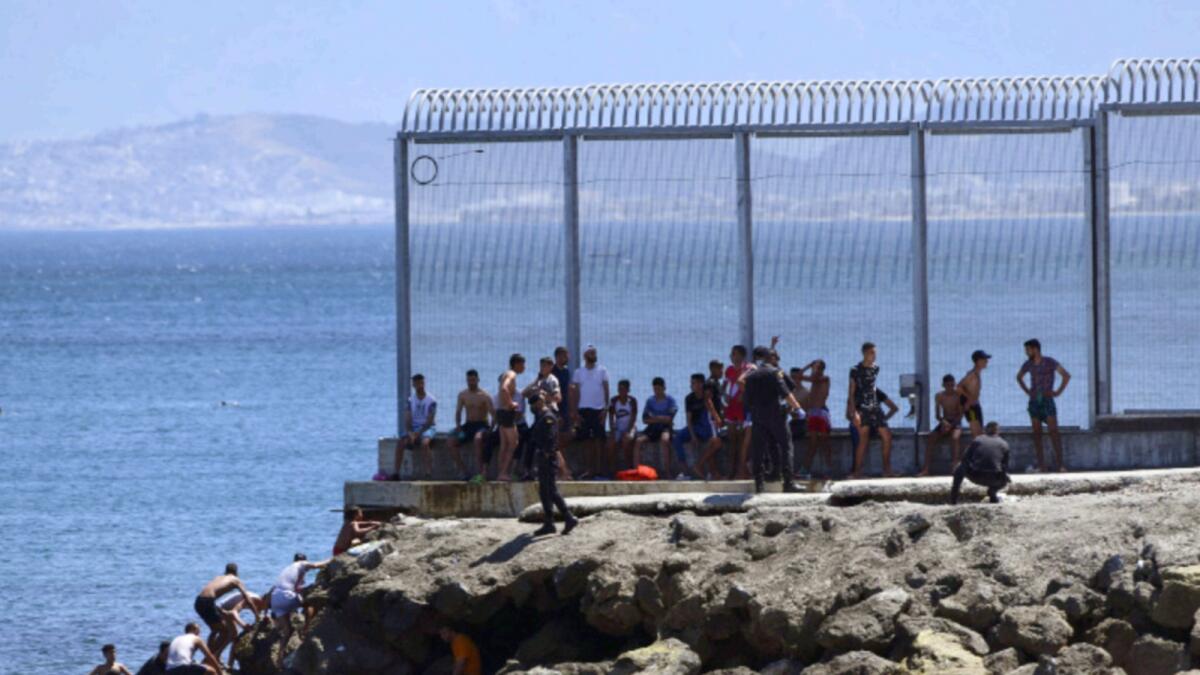 Spanish Guardia Civil officers try to stop people from Morocco entering into the Spanish territory at the border of Morocco and Spain, at the Spanish enclave of Ceuta on Monday. — AP