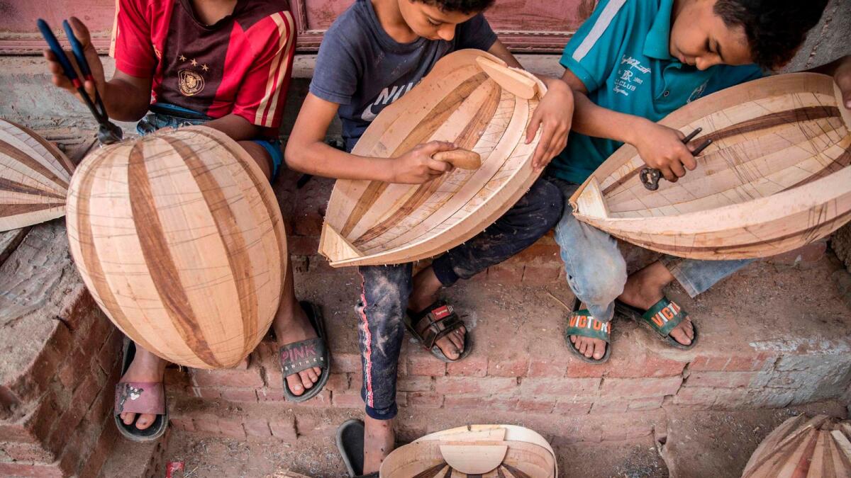 Children work on Arabian Ouds at a workshop belonging to Khaled Azzouz, a veteran oud-maker at the Al Marg district on the outskirts of the Egyptian capital Cairo.