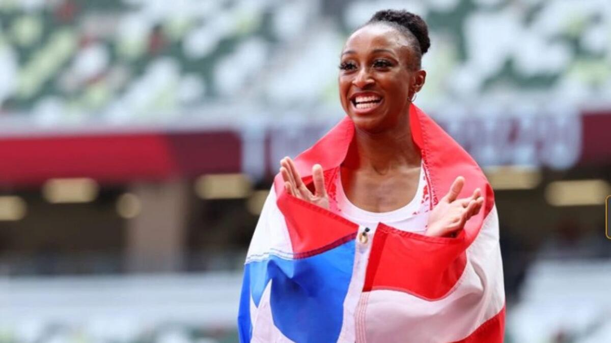Jasmine Camacho-Quinn of Puerto Rico celebrates with her national flag after winning the gold medal. (Reuters)