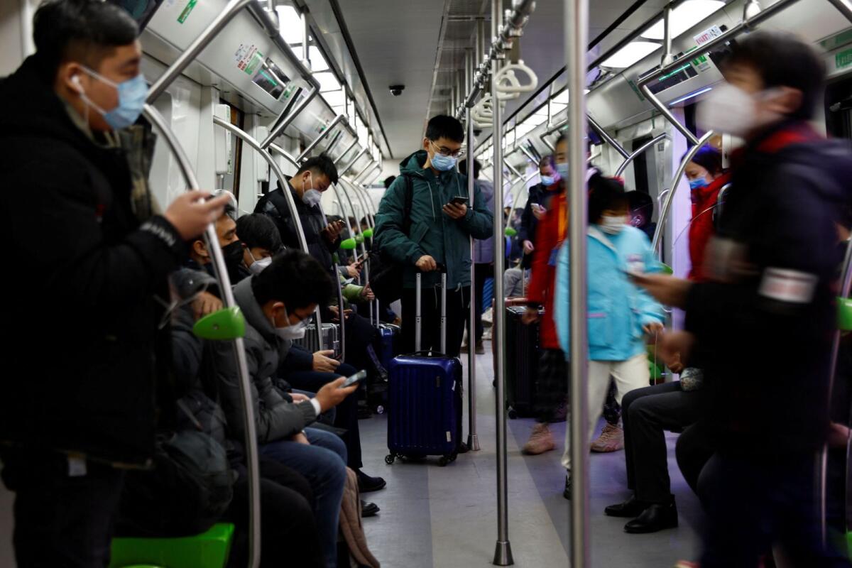 Passengers ride on a subway with suitcases on a subway in Beijing, China. — Reuters file