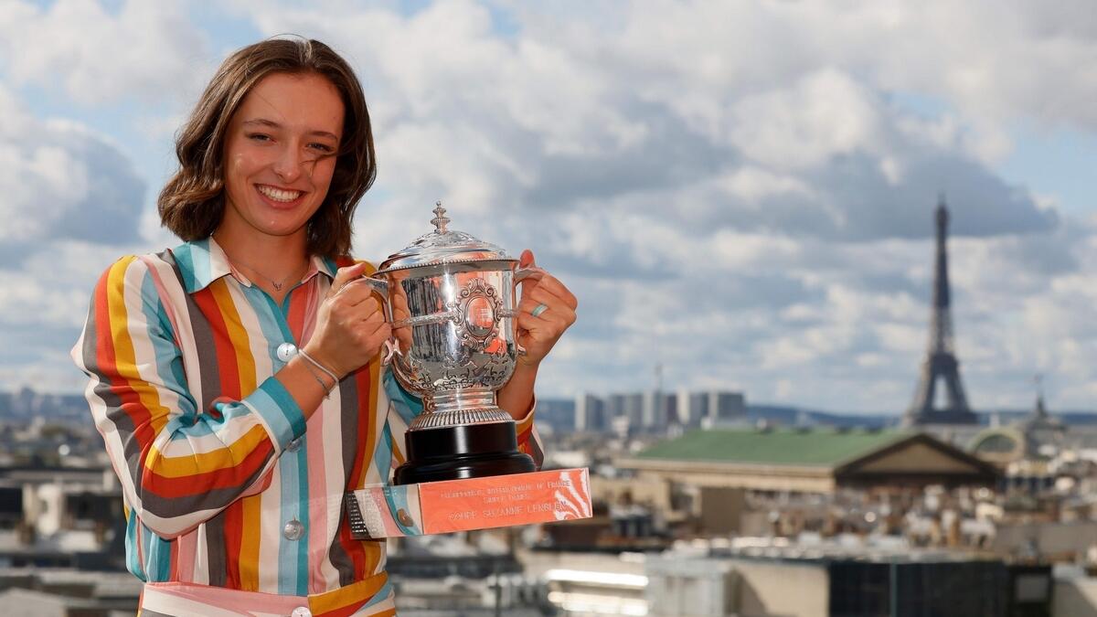 Poland's Iga Swiatek poses with the trophy Suzanne Lenglen near the Eiffel Tower in Paris