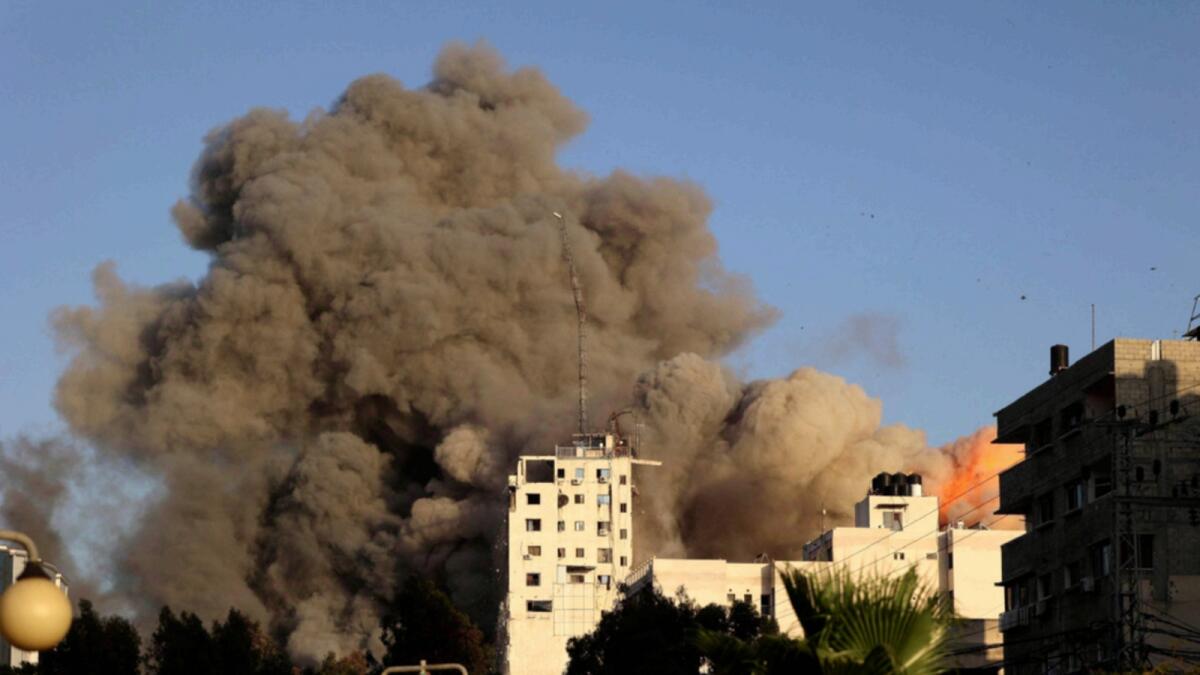 Smoke rises from Al Sharouk tower hit by an Israeli air strike in Gaza City. — AFP