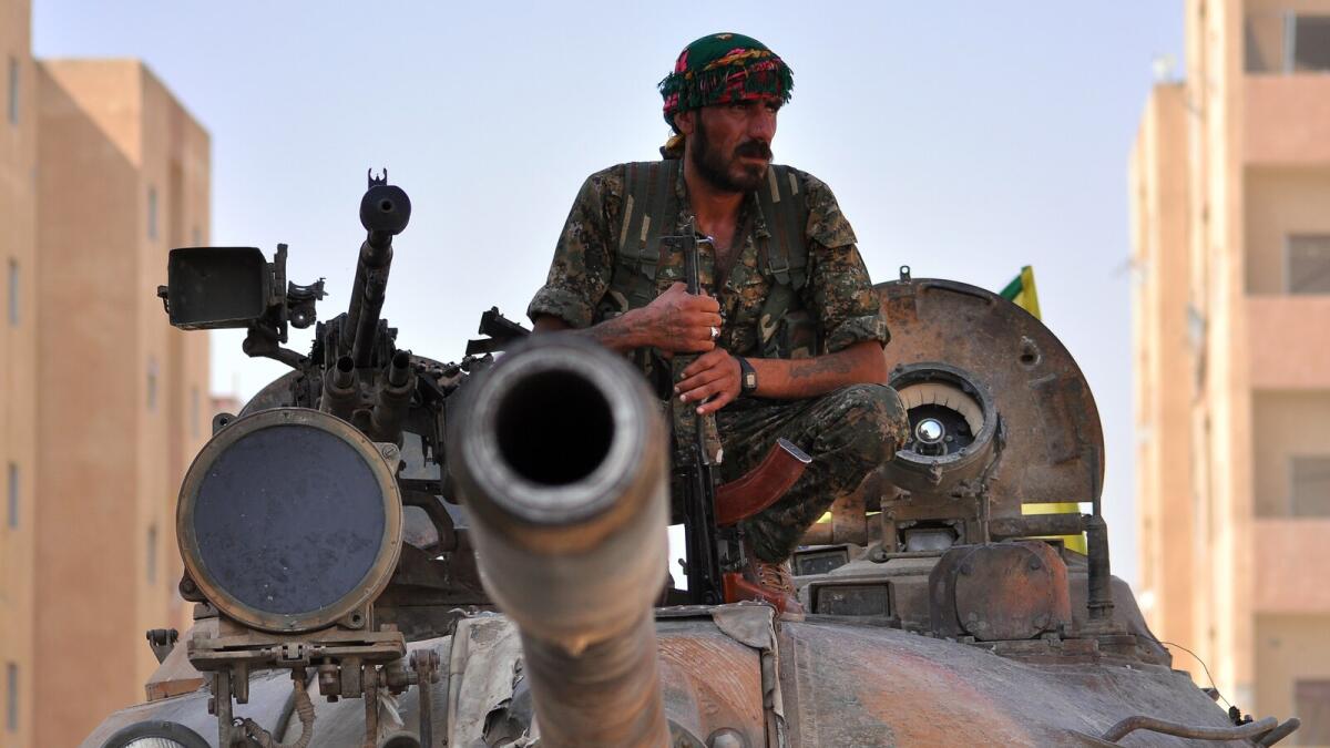 A fighter from the Kurdish People’s Protection Units (YPG) sits on a tank in the Al Zohour nieighbourhood of northeastern Syrian city of Hasakeh. — AFP