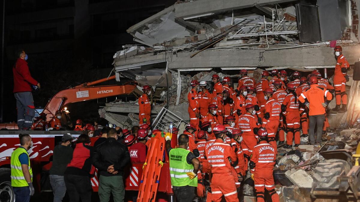Rescuers search for survivors among the rubble of a collapsed building after a powerful earthquake struck Turkey's western coast and parts of Greece, in Izmir, on October 30, 2020.