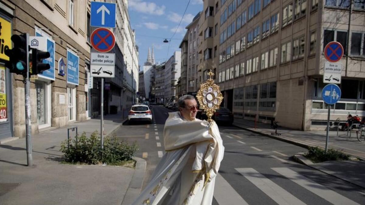 Priest Ivan Matic walks with a cross and blesses believers during Easter, in Zagreb, Croatia. Photo: Reuters