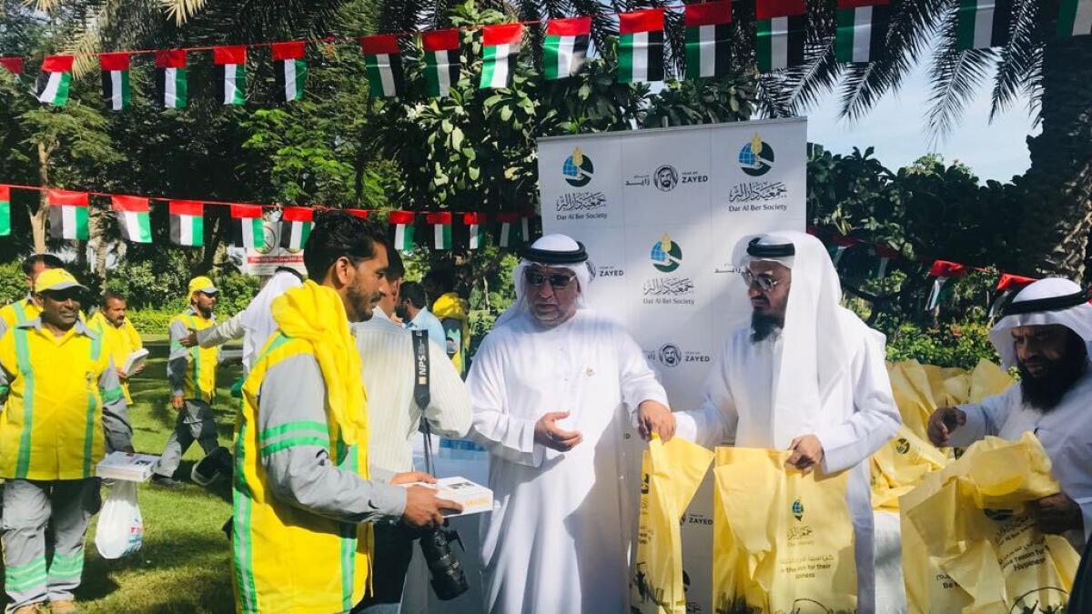 Dar Al Ber society and Dubai Municipality officials give out pizzas and goody bags to workers.-Supplied photo 