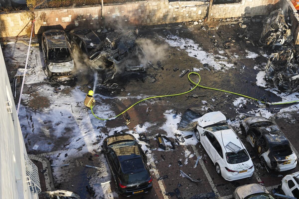 Israeli firefighters extinguish fire after a rocket fired from the Gaza Strip hit a parking lot in Ashkelon, southern Israel, Saturday, Oct. 7, 2023. Photo: AP