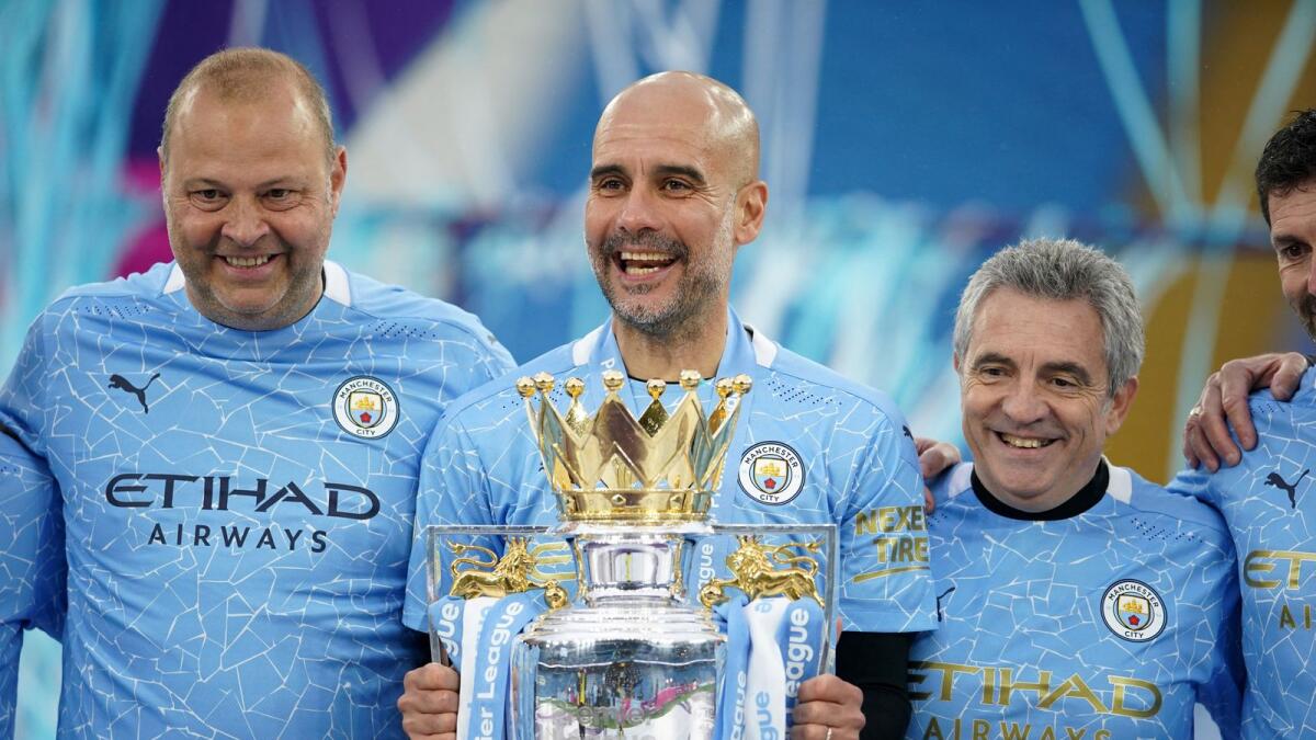 Manchester City manager Pep Guardiola (centre) holds the Premier League trophy during the award ceremony. (AFP)
