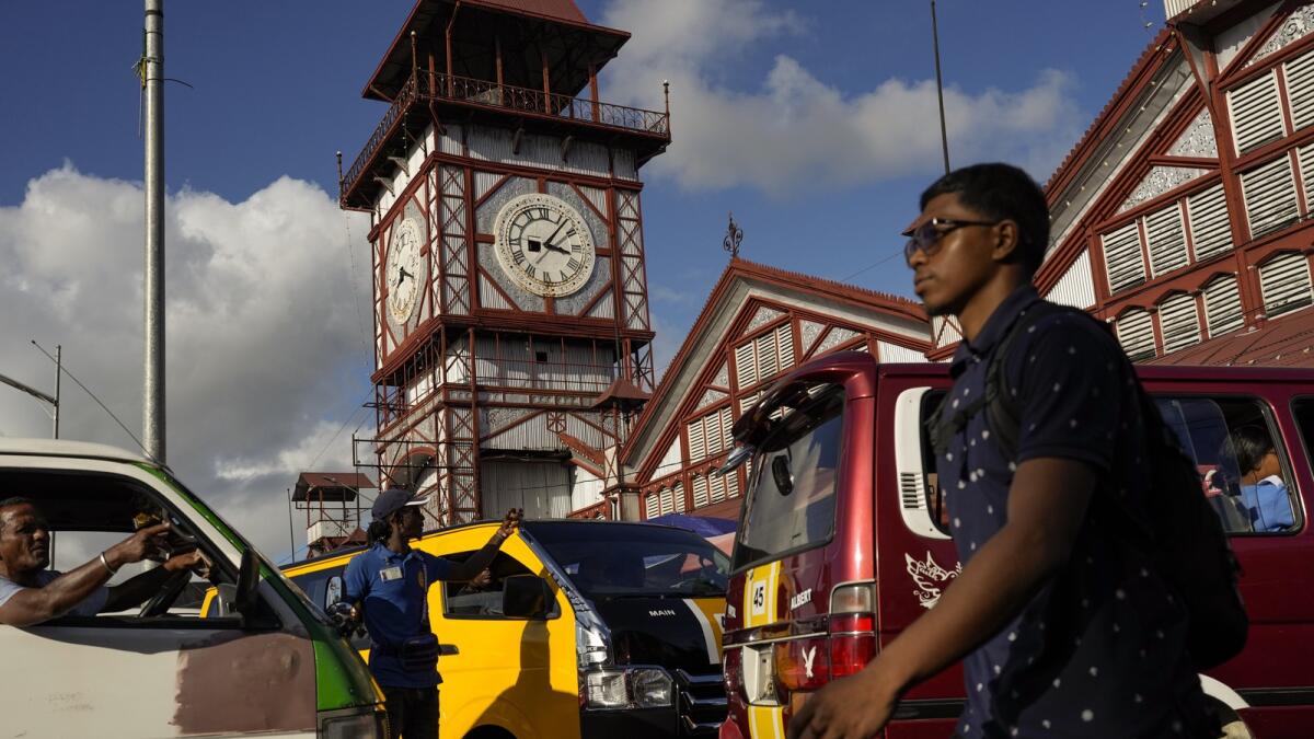 Drivers are stuck in traffic near the Stabroek Market in Georgetown, Guyana. Despite the nation's oil boom, poverty is deepening for some as the cost of living soars, with goods such as sugar, oranges, cooking oil, peppers and plantains more than doubling in price while salaries have flatlined. — AP