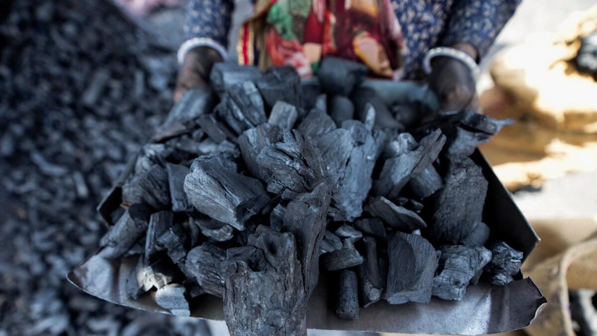 A woman works at a coal depot in Ahmedabad, India. — AP file