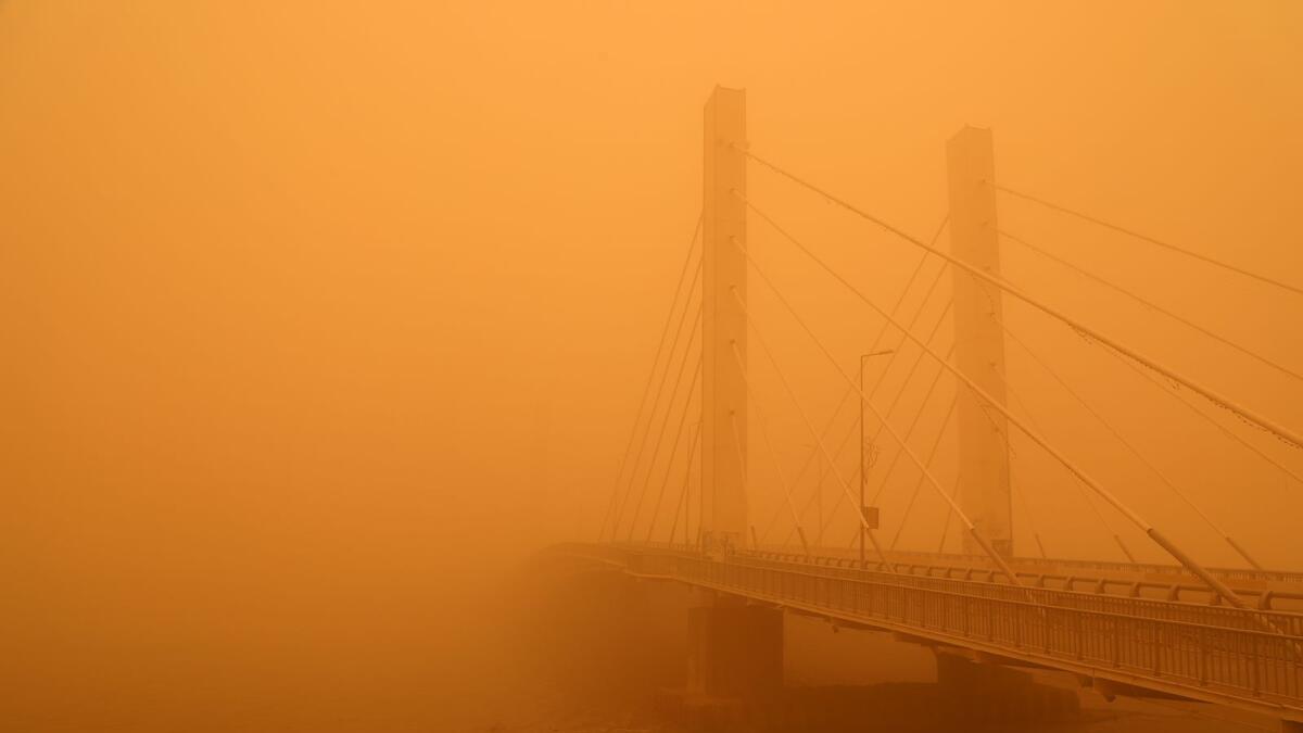 This picture taken on May 23, 2022 shows a view of the Hadarat bridge across the Euphrates river amidst a heavy dust storm in the city of Nasiriyah in Iraq's southern Dhi Qar province. Photo: AFP