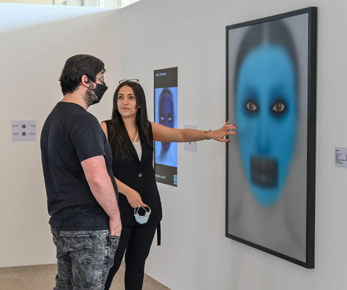 Visitors are looking at the digital artwork displayed at Sharjah's first NFT art exhibition, 'Gateway to the Metaverse' hosted by House of Wisdom - Photo by M. Sajjad
