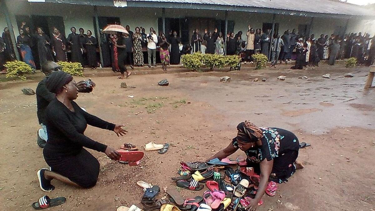 Parents of students abducted at Bethel Baptist High School pray for their safe return around discarded shoes left behind by the children