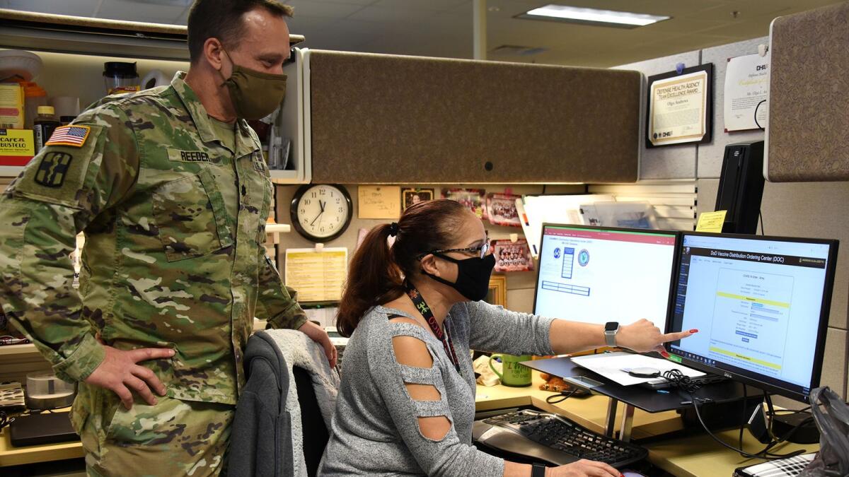 United States Army Medical Materiel Agency (USAMMA) pharmacy consultant and Distribution Operations Center Director Lieutenant Colonel Todd Reeder speaks with deputy director Liz Andrews about the progress of the Covid-19 vaccines.