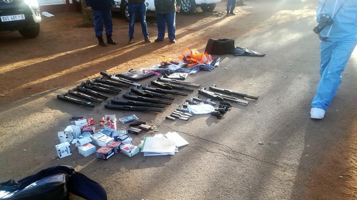 In this photo made available by the South African Police Services (SAPS), confiscated arms and ammunition, lay on the ground at a church in Zuurbekom, near Johannesburg, Saturday, July 11, 2020. Police in South Africa say five people are dead and more than 40 have been arrested after an early-morning hostage situation at a church near Johannesburg. AP