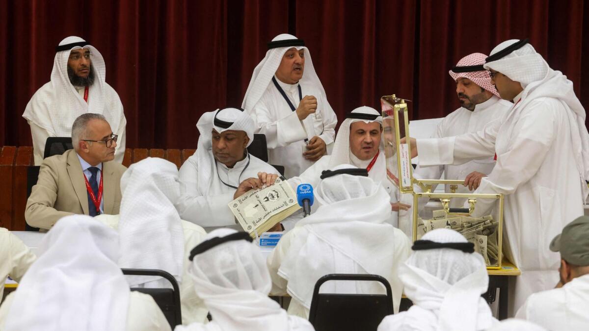 A Kuwaiti judge and his aides count the ballots at a polling station for parliamentary elections in the Abdullah Al Salem district of Kuwait city, on Tuesday. --- AFP