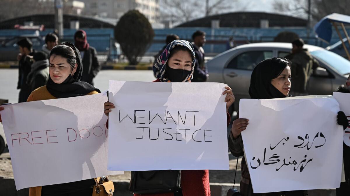 Women hold placards during a protest to demand an end to the extra-judicial killings of former officials of the previous regime, in Kabul on December 28, 2021. (Photo: AFP)