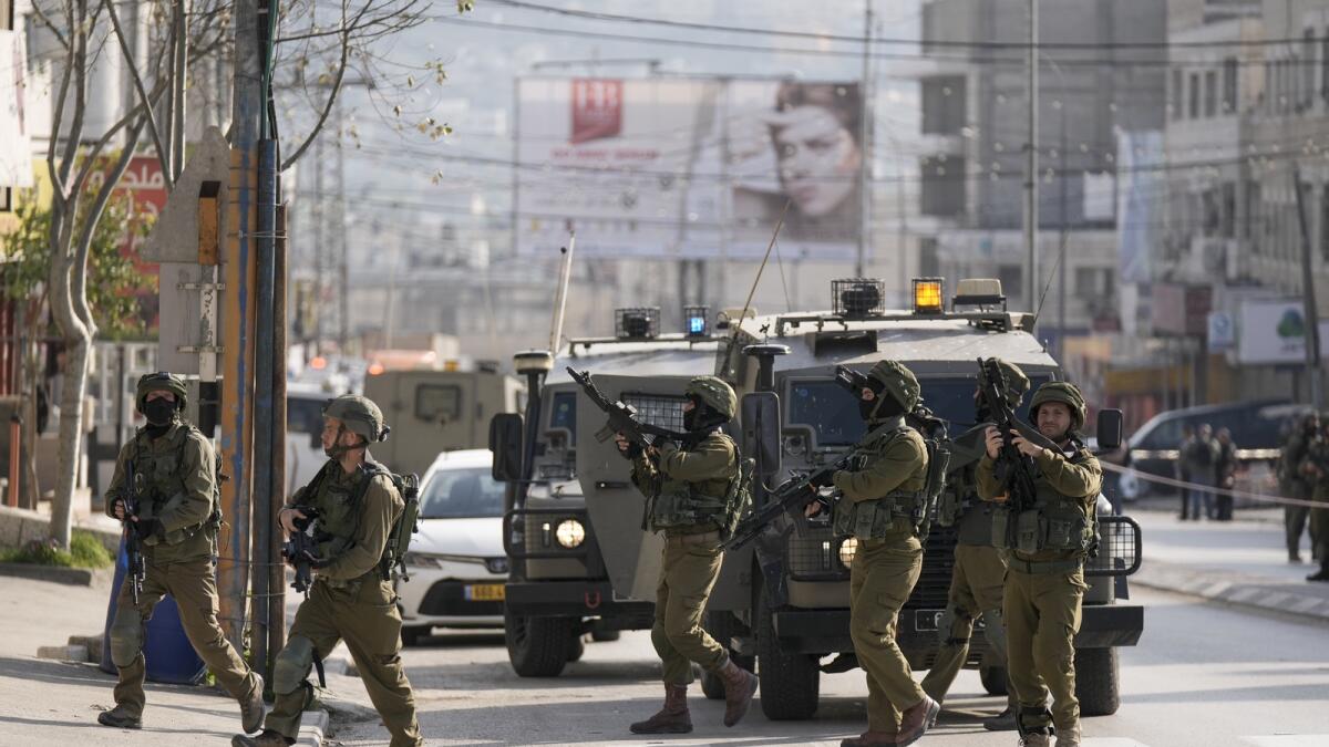 Israeli soldiers take up positions at the scene of a Palestinian shooting attack at the Hawara checkpoint, near the West Bank city of Nablus. — AP