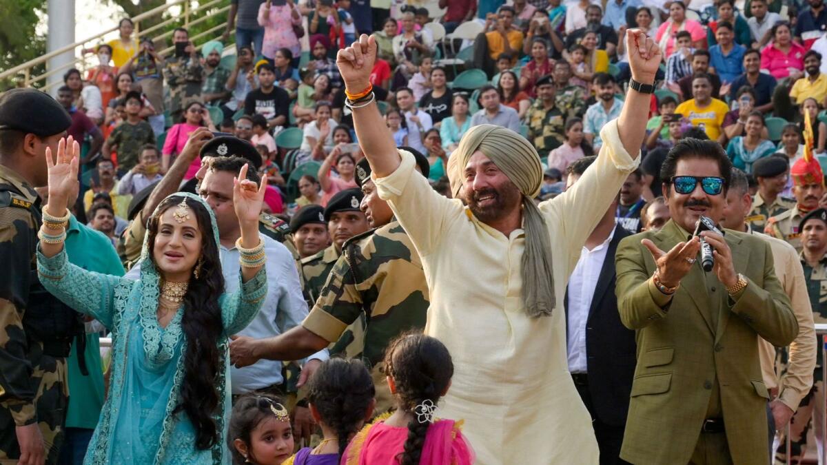 Bollywood actors Sunny Deol (C), Ameesha Patel (L) with playback singer Udit Narayan (R) attend the promotion of ‘Gadar 2’ at the India-Pakistan Wagah border post. — AFP