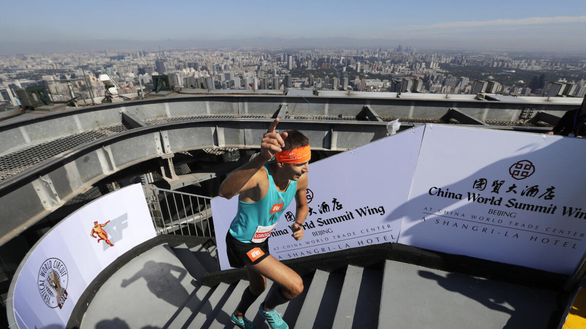Polish runner Piotr Lobodzinski gestures as he races to finish the last steps to win the men's race at China World Summit Wing Hotel Vertical Run on top of the China World Trade Tower 3 in Beijing, Saturday, Aug. 3, 2016. The race participants climbed 82 floors, covering a total of 2,041 steps, to the top of the 330-meter (1083-foot) tower located at Beijing's Central Business District. (AP Photo/Andy Wong)