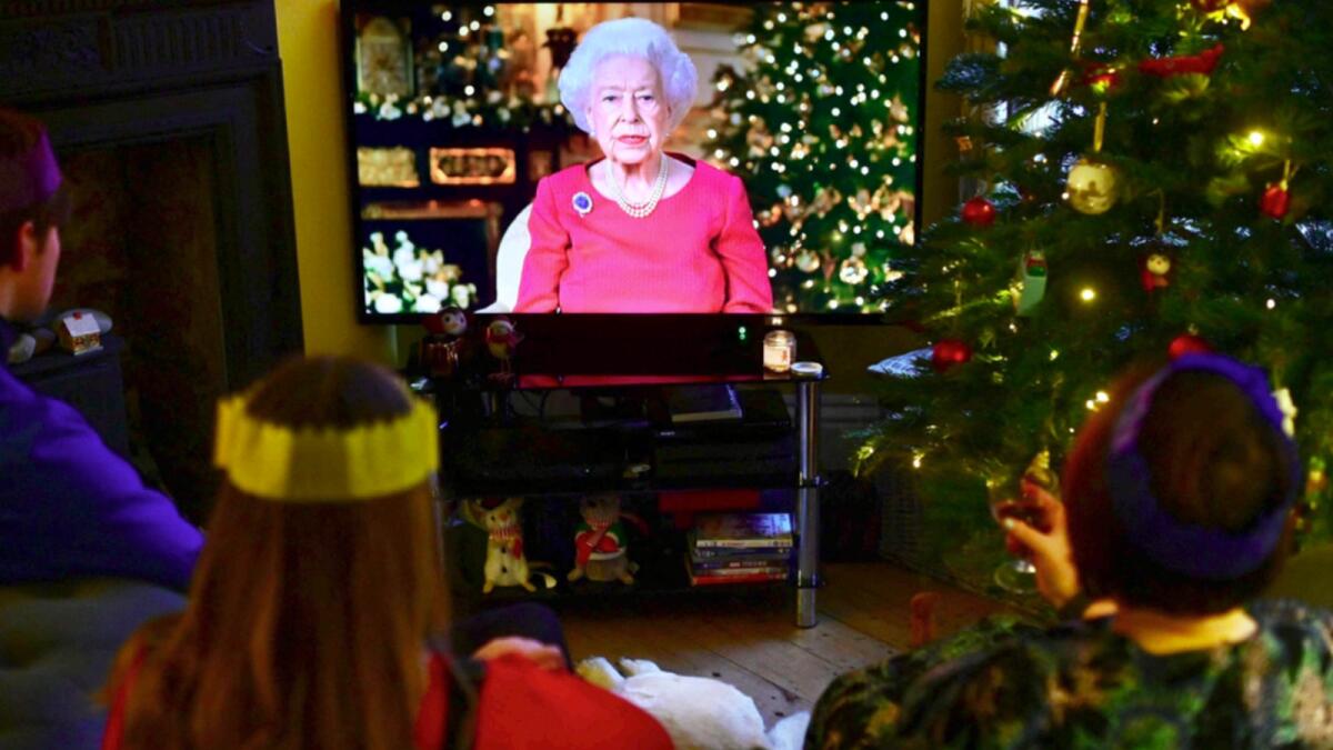 A family watch as Britain's Queen Elizabeth II delivers her annual Christmas Broadcast message, at their home near Liverpool. — AFP