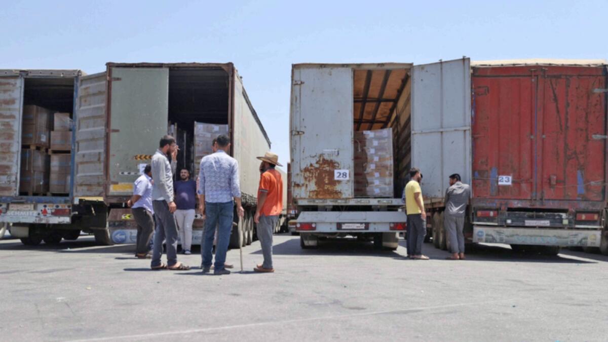 Customs officers inspect a convoy of humanitarian aid after crossing into Syria from Turkey through the Bab Al Hawa border crossing. — AFP