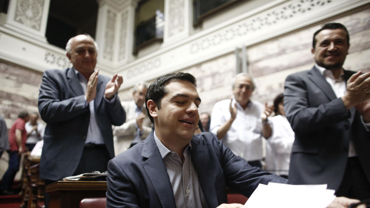 Alexis Tsipras, Greece's prime minister, center, reacts after arriving at the Greek parliament to address lawmakers in Athens, Greece, on Friday, July 10, 2015. In an 11th-hour bid to stay in the euro, the government of Tsipras offered to meet most of the demands made by creditors in exchange for a bailout of 53.5 billion euros ($59.4 billion). Photographer: Kostas Tsironis/Bloomberg *** Local Caption *** Alexis Tsipras