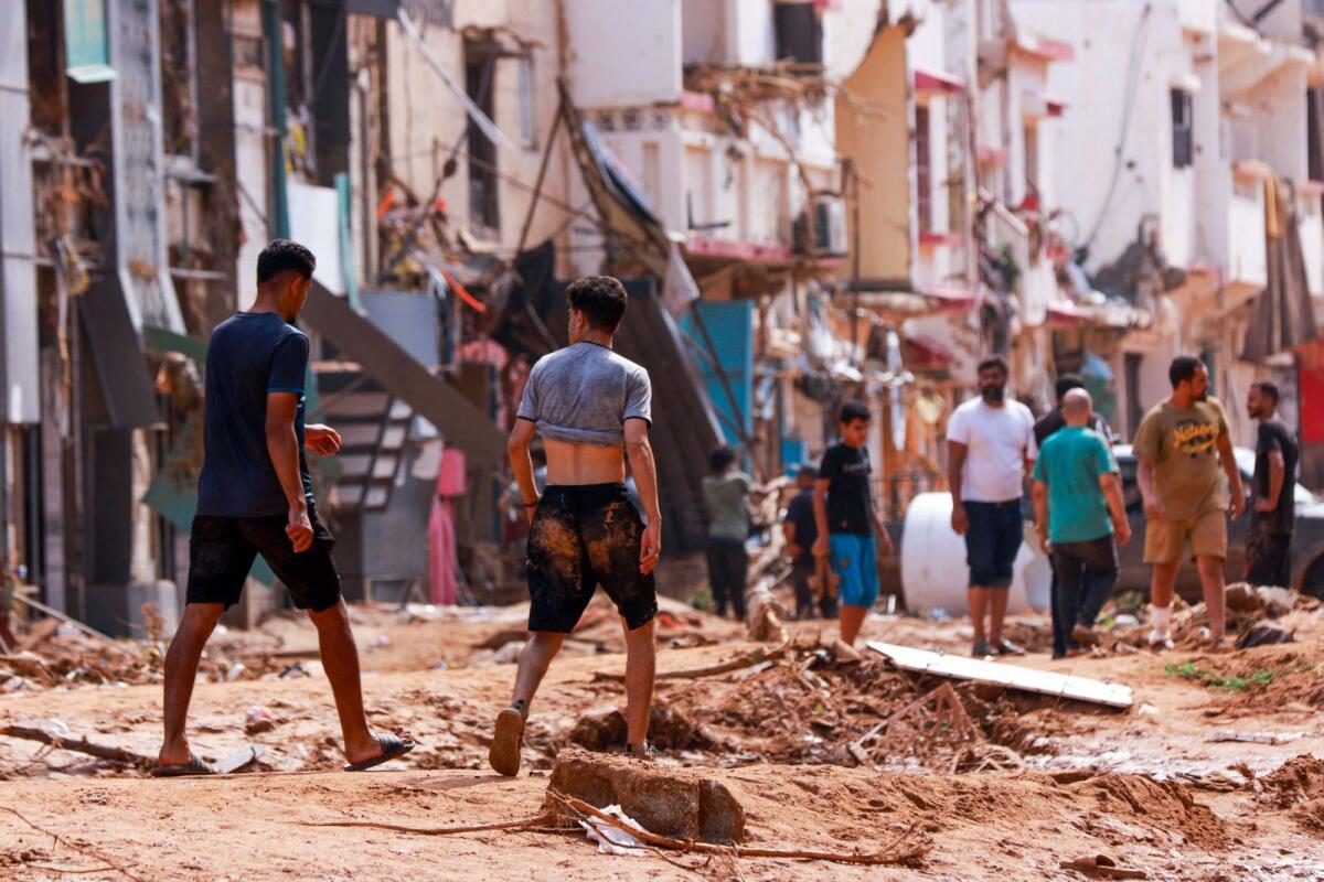 People check an area damaged by flash floods in Derna, eastern Libya, on September 11, 2023.