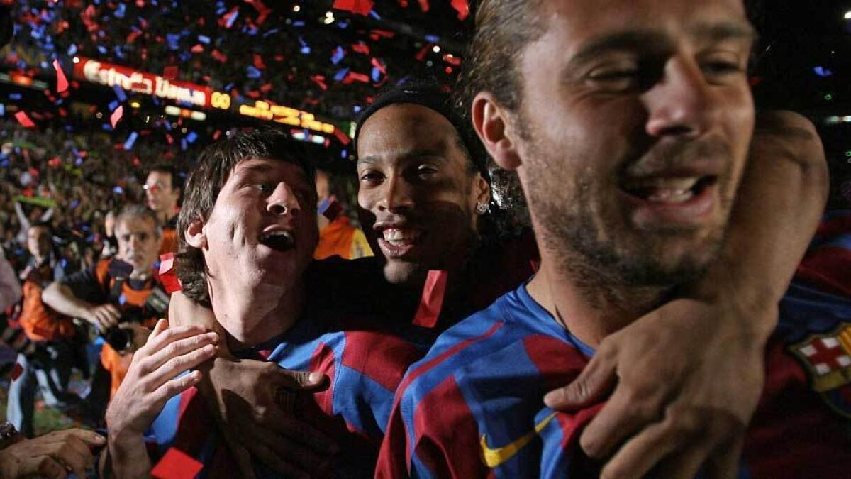 Messi celebrates with team-mates Ronaldinho and Rafael Marquez after Barcelona won the La Liga title in May, 2006