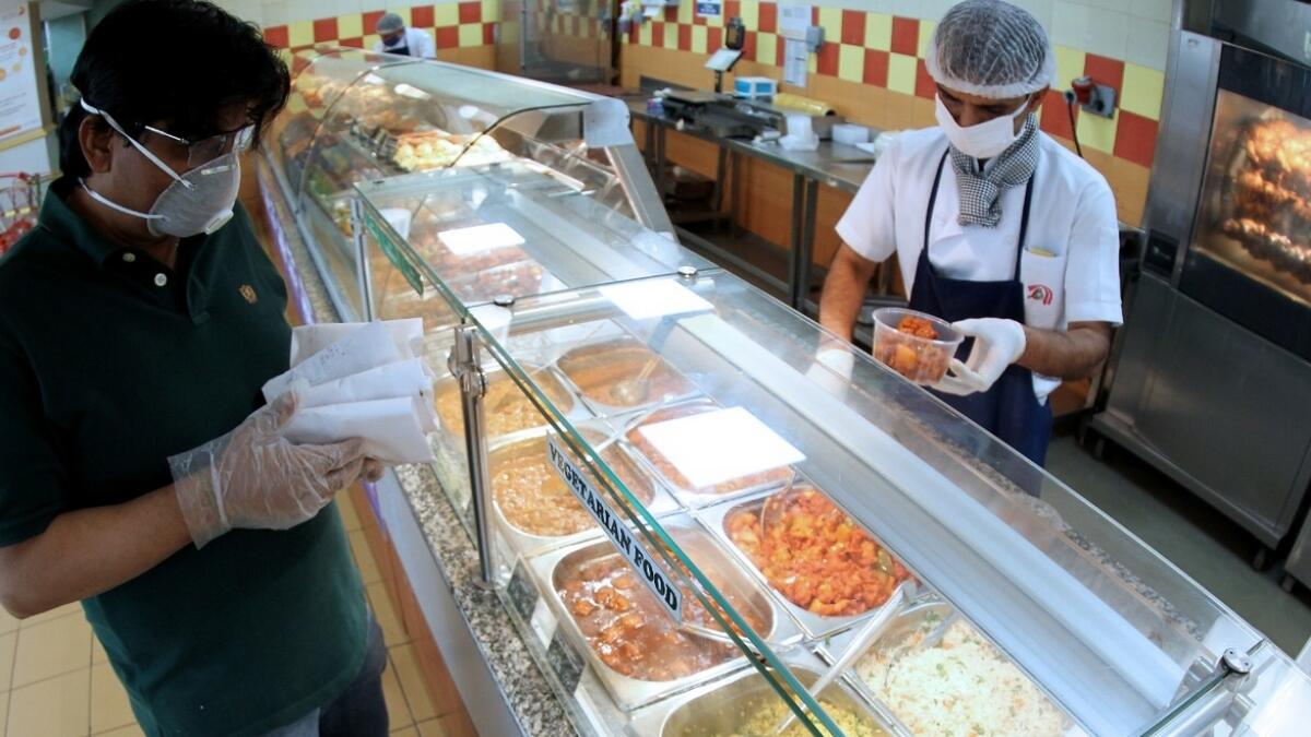 People at a take away counter inside a supermarket in Dubai. As part of preventive measures, all restaurants, cafes, cafeterias, coffee shops and food service establishments across Dubai closed for two weeks starting from Tuesday, March 24. Only food delivery services and take away are permitted in the UAE.