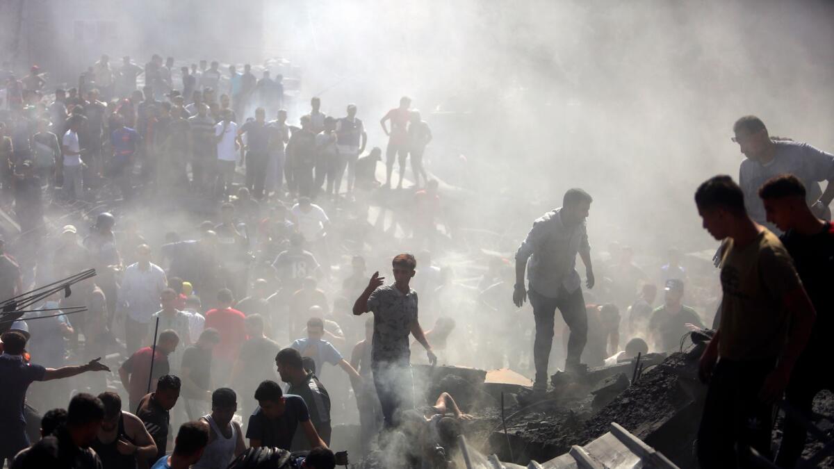 Palestinians inspect the rubble of destroyed buildings following Israeli airstrikes on the town of Khan Younis. — AP