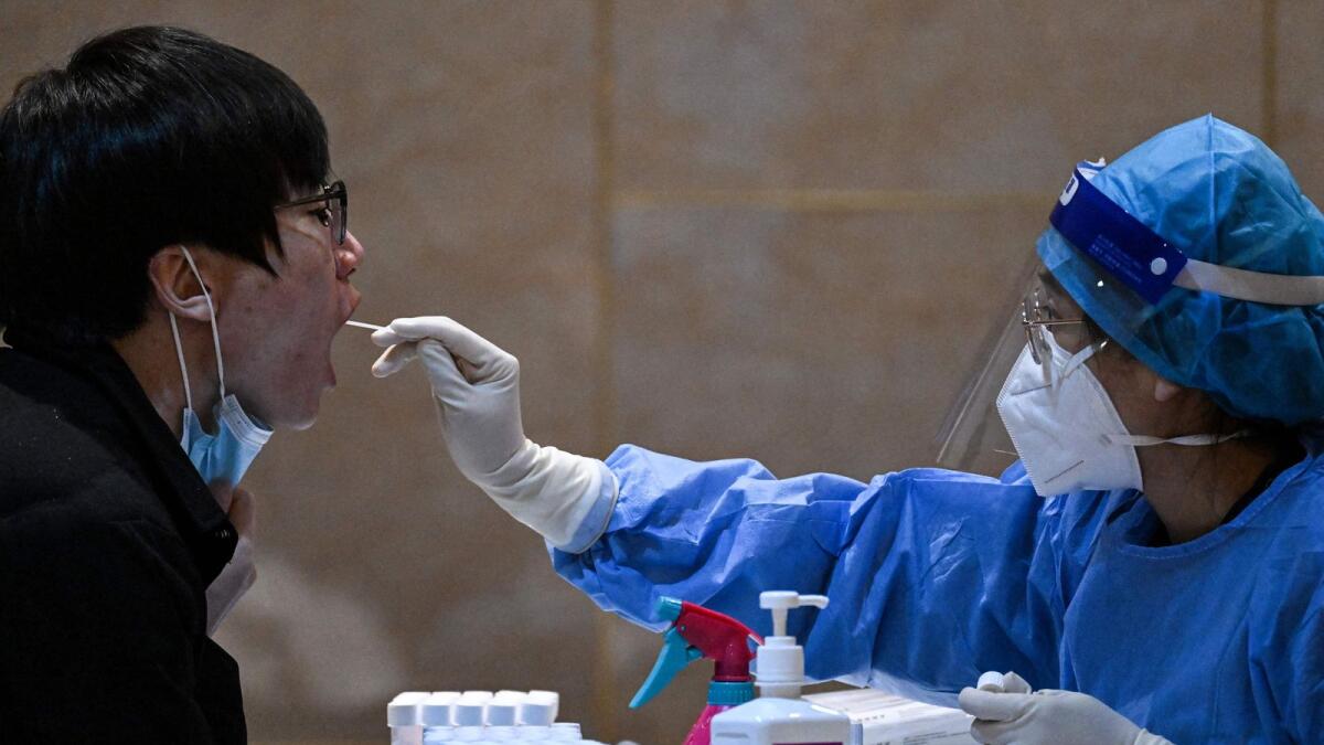 A health worker takes a swab sample from a journalist to be tested for Covid-19, the night before the 14th Committee of the Chinese People's Political Consultative Conference (CPPCC) in Beijing. — AFP
