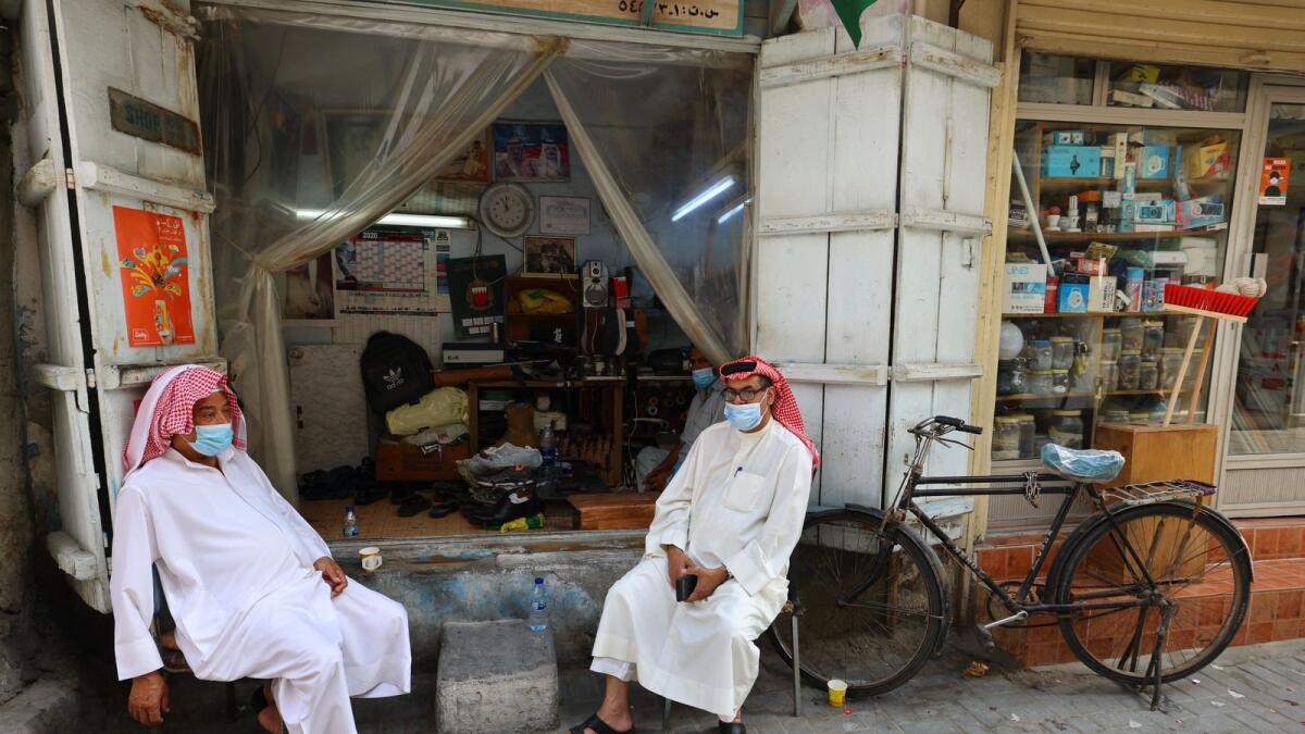 Bahrainis sit outside a shop at the Suq al-Qaisariya, in Muharraq Island, Manama. Photo: AFP