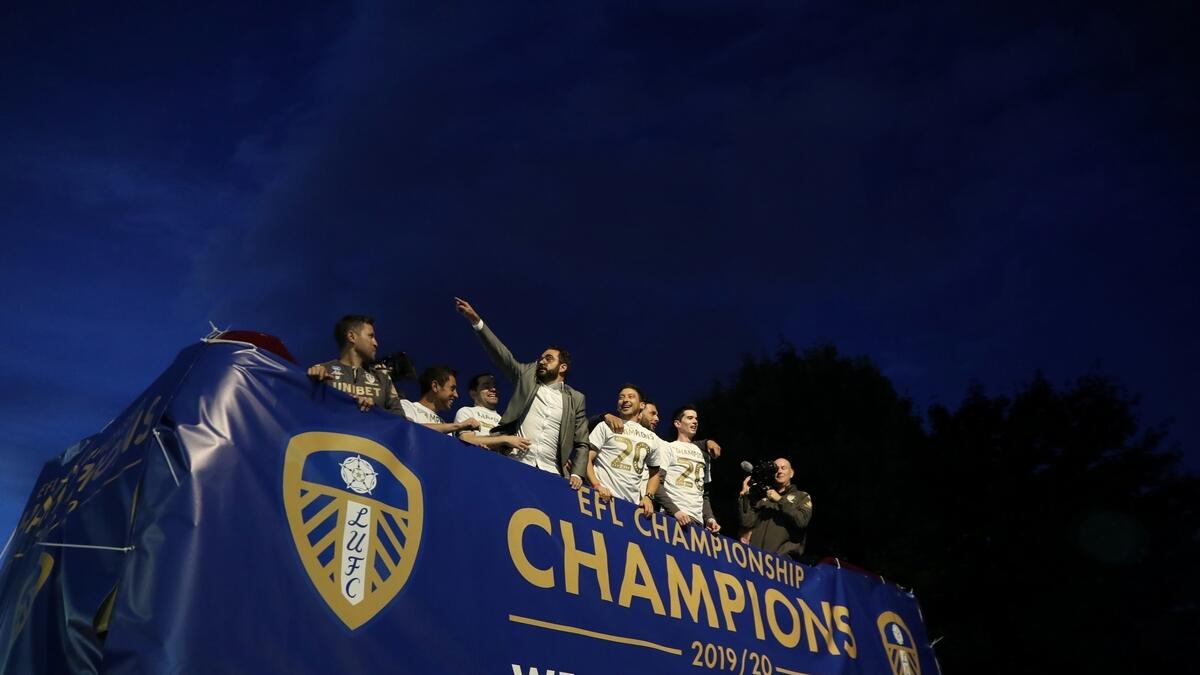 Leeds United players celebrate winning the Championship and promotion to the Premier League outside the stadium