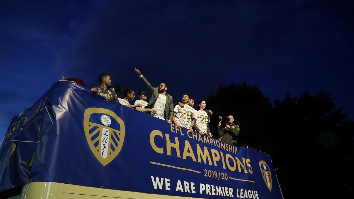Leeds United players celebrate winning the Championship and promotion to the Premier League outside the stadium