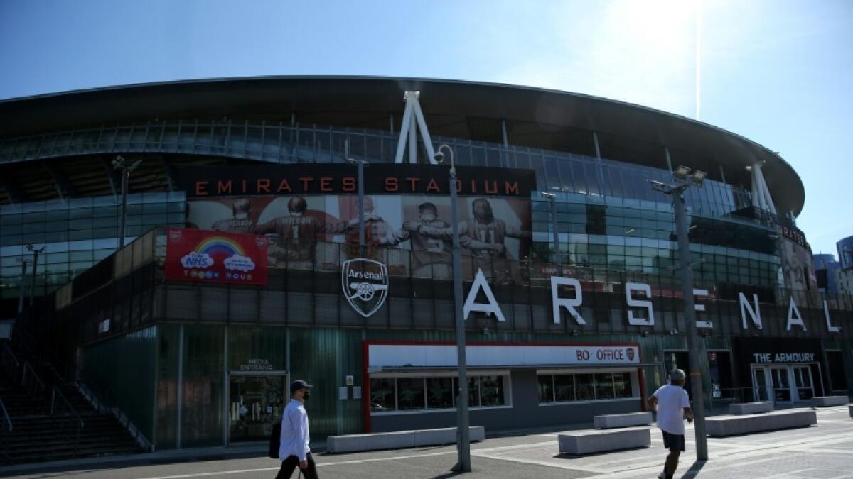 People walk in front of Arsenal's Emirates Stadium. - AFP file