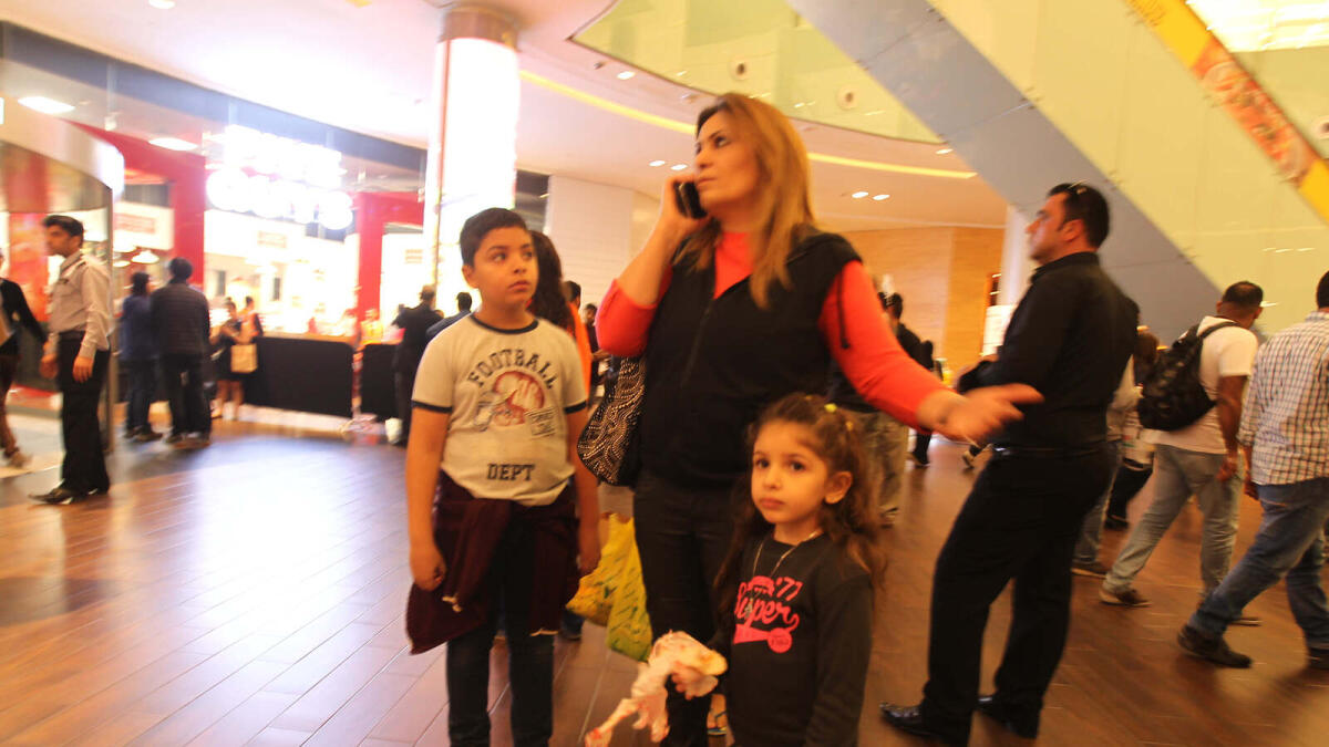 A woman stranded with her children at The Dubai Mall frantically calls up her near and dear ones. Photo by Rahul Gajjar