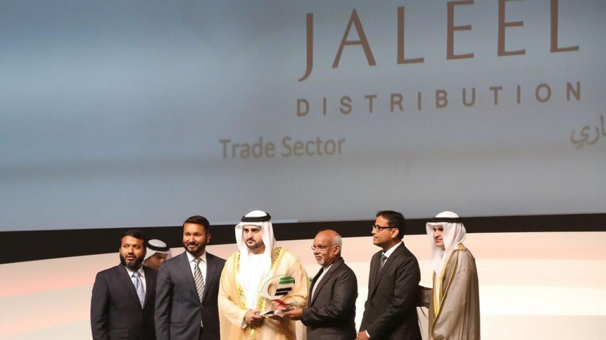 Shaikh Maktoum bin Mohammed bin Rashid Al Maktoum, Deputy Ruler of Dubai, presents the Dubai Quality Appreciation Award - 2015 in trade sector to  Kunhu Mohamed Venmadathayil, chairman and Sameer K. Mohamed, managing director of Jaleel Holdings. Also seen