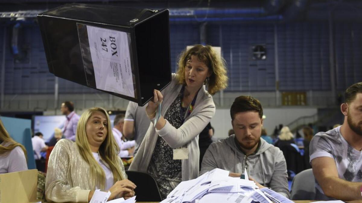 Workers begin counting ballots after polling stations closed in Glasgow, Scotland.