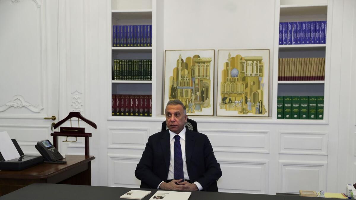 Iraqi Prime Minister Mustafa Al Kadhimi poses in his office during an interview. AP