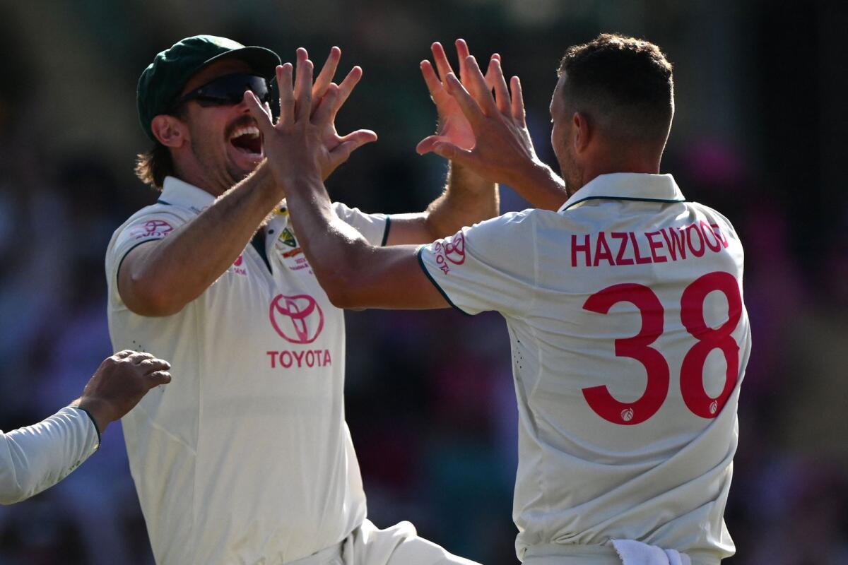 Australia’s Josh Hazlewood celebrates with Mitch Marsh after taking the wicket of Pakistan’s Salman Ali Agha. Photo: AFP