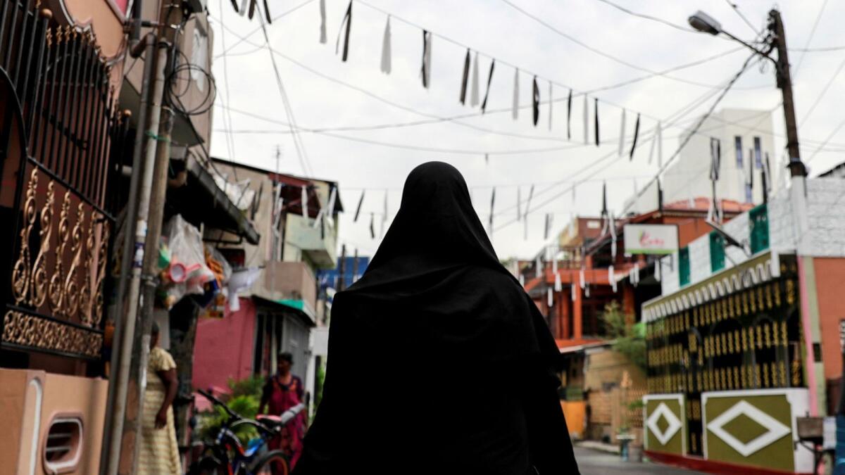 A Muslim woman wearing burqa walks through a street near St Anthony's Shrine in Colombo.
