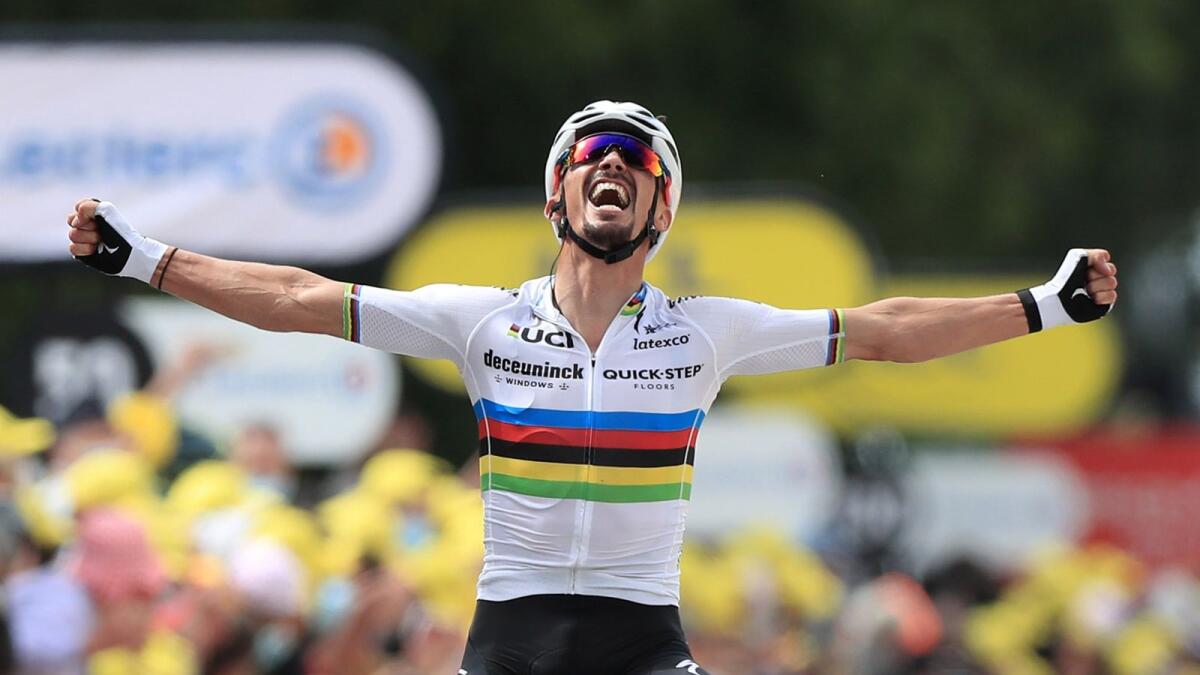 Quick-Step rider Julian Alaphilippe of France celebrates as he crosses the finish line to win the first stage. (Reuters)